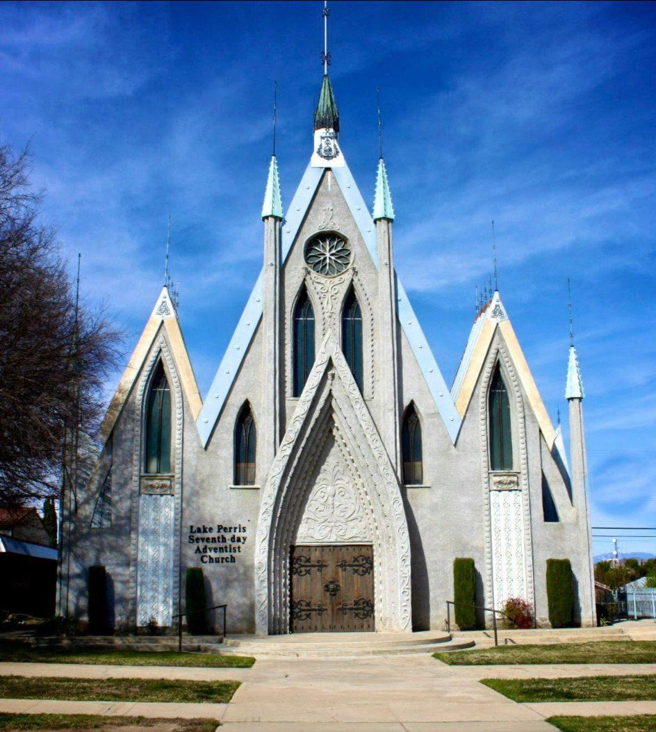 The white spires and carved arch entrance of Perris Seventh-day Adventist Community Church